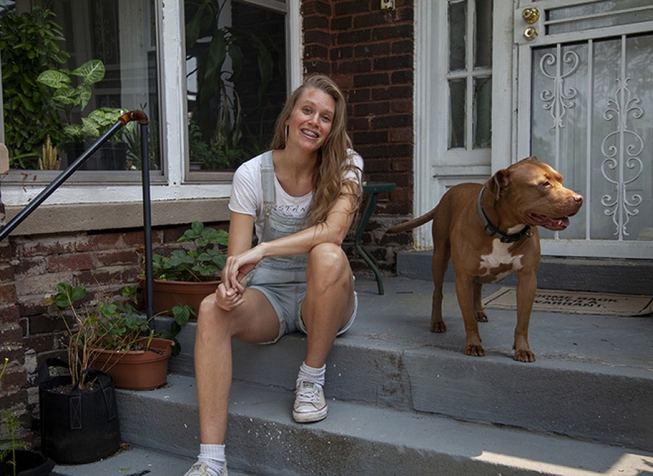 Emma Howland-Bolton and her dog on the porch of her home in Virginia Park